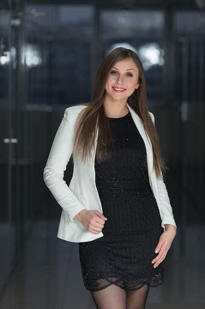 Souriante jeune femme d'affaires au bureau en regardant la caméra.