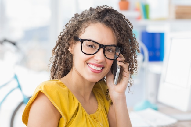 Souriante jeune femme d&#39;affaires au téléphone