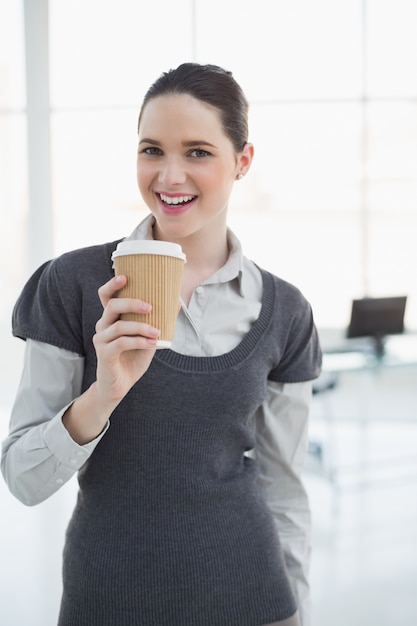 Souriante jeune femme d&#39;affaires tenant le café