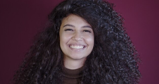 Souriante jeune femme afro latine. Joie, positif et amour. De beaux cheveux à l'africaine