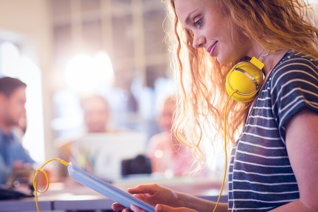 Souriante jeune femme à l&#39;aide de tablette numérique