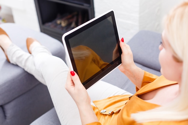 Souriante jeune femme à l'aide de tablette numérique