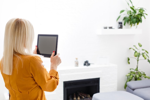 Souriante jeune femme à l'aide de tablette numérique