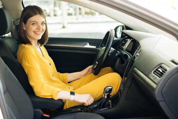 Souriante jeune femme appréciant la conduite par une belle journée ensoleillée jolie femme adorable équitation voiture