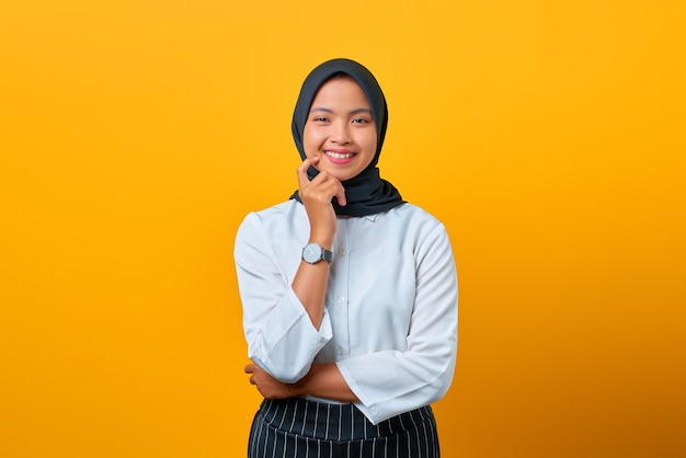 Souriante jeune femme asiatique avec une apparence agréable sur fond jaune