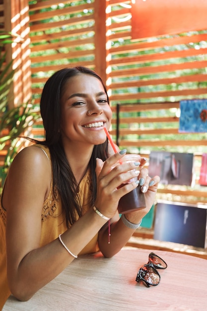 Souriante jeune femme assise au café