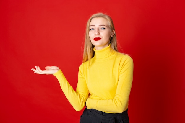 Souriante jeune femme blonde en regardant la caméra