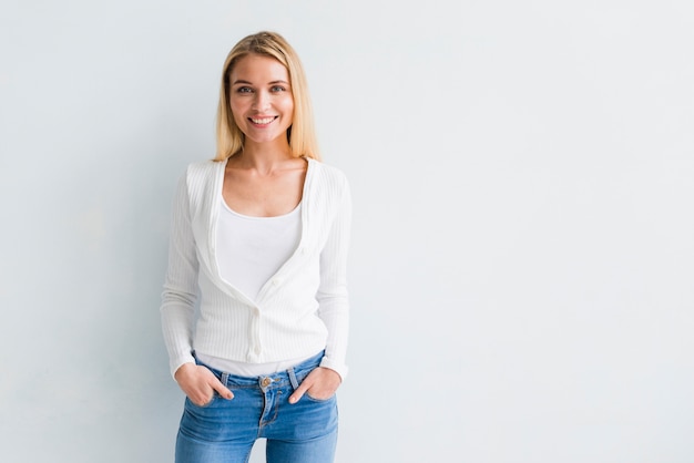 Souriante jeune femme blonde en vêtements décontractés