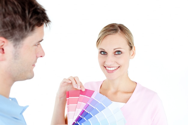 Souriante jeune femme en choisissant des couleurs pour peindre une chambre