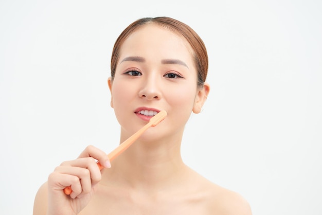 Souriante jeune femme avec des dents saines tenant une brosse à dents