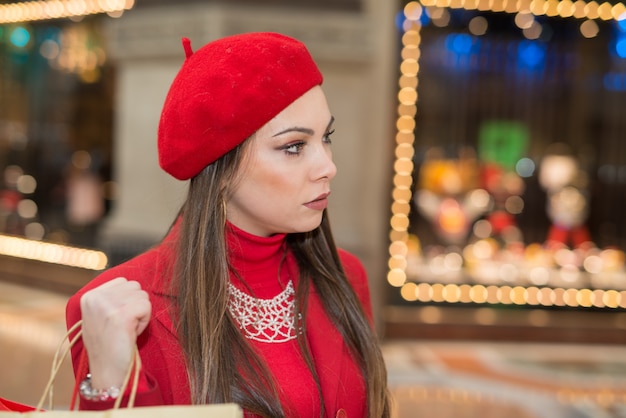 Souriante jeune femme faisant du shopping dans une ville avant Noël