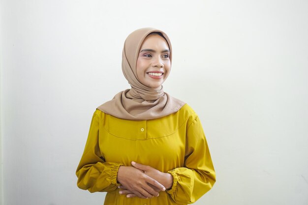Souriante jeune femme musulmane asiatique se sent confiante et joyeuse isolée sur fond blanc