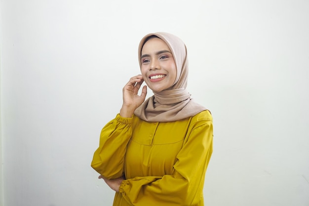 Souriante jeune femme musulmane asiatique se sent confiante et joyeuse isolée sur fond blanc
