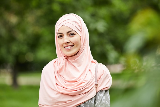 Souriante jeune femme musulmane dans le parc