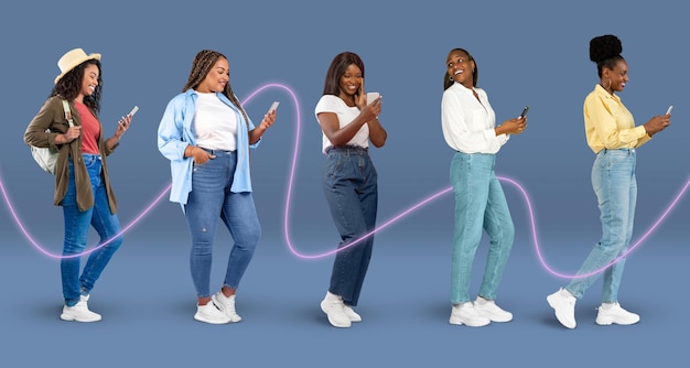 Souriante jeune femme noire en dactylographie occasionnelle sur smartphone avec ligne de connexion sur fond bleu