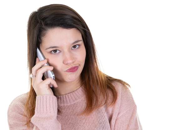 Souriante jeune femme parlant au téléphone portable sur fond blanc