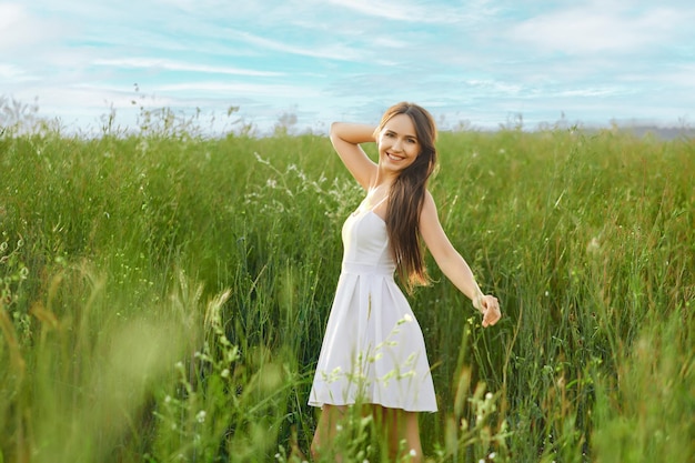 Souriante jeune femme en robe d'été sur le terrain