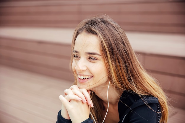 Souriante jeune femme avec smartphone et casque d&#39;écoute de la musique