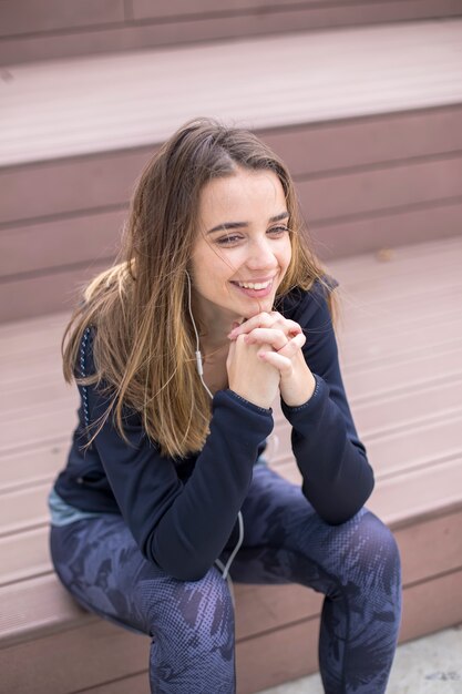 Souriante jeune femme avec smartphone et casque d'écoute de la musique