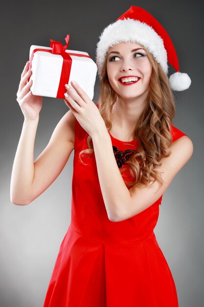 Souriante jeune femme tenant des cadeaux de Noël