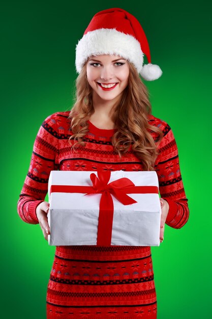 Souriante jeune femme tenant des cadeaux de Noël
