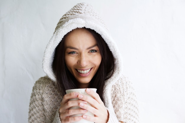 Souriante jeune femme tenant une tasse de café