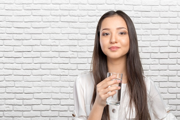 Souriante jeune femme avec un verre d&#39;eau