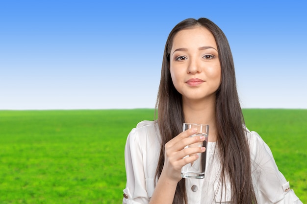 Souriante jeune femme avec un verre d&#39;eau