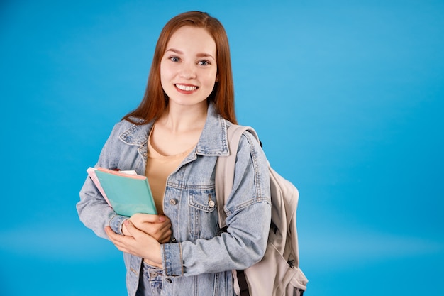 Souriante jeune fille au gingembre en t-shirt et veste en jean