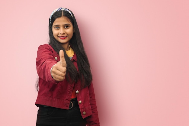 Souriante Jeune Indienne Asiatique Satisfaite fille réussie posant isolé avec le geste du pouce vers le haut Espace de copie maquette