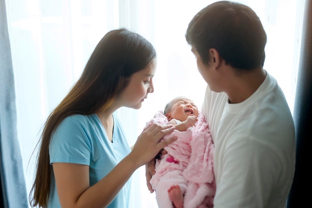 Souriante jeune mère et père avec un concept de famille et d'amour nouveau-né