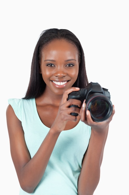 Souriante jeune photographe avec son appareil photo