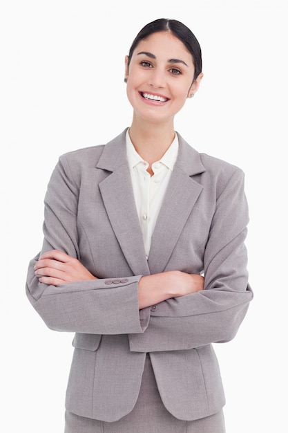 Souriante jeune vendeuse avec les bras croisés