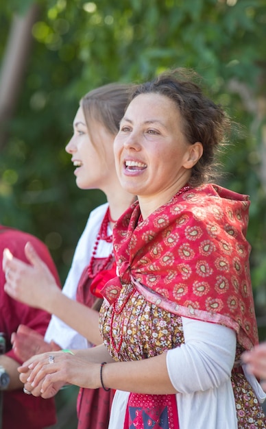 Souriante jeunes femmes en costumes folkloriques russes sur le fond de l'arbre