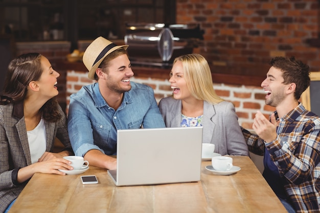 Sourire des amis, boire du café et rire