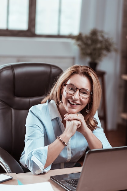 Sourire Au Travail. Femme Blonde Mature Séduisante Portant De Belles Boucles D'oreilles Souriant Au Travail