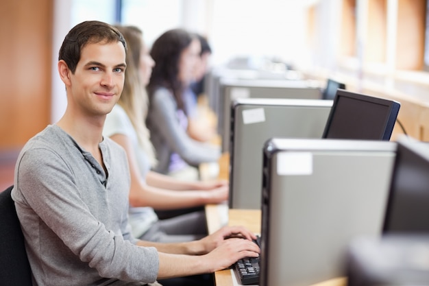 Sourire à d&#39;autres étudiants dans une salle informatique