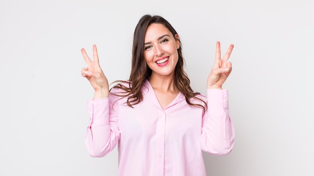 Sourire et avoir l'air heureux, amical et satisfait, gestant la victoire ou la paix avec les deux mains