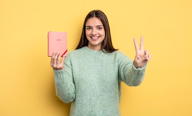 Sourire et avoir l'air heureux de faire des gestes de victoire ou de paix