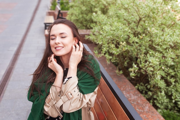 Sourire belle fille dans la ville. Vent développant les cheveux longs d'une jeune femme heureuse. Portrait d'une jolie fille aux yeux fermés. Copier l'espace