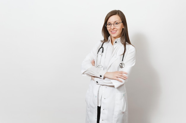 Sourire confiant belle jeune femme médecin avec stéthoscope, lunettes isolées sur fond blanc. Une femme médecin en blouse médicale tient les mains jointes. Personnel de santé, santé, concept de médecine.