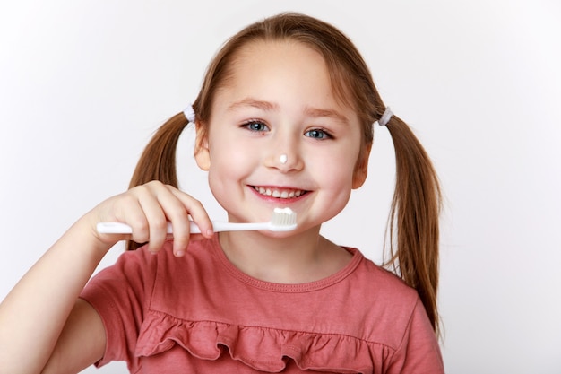 Photo sourire content de petite fille en se brossant les dents