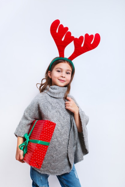 Sourire drôle fille en cornes de cerf en studio.