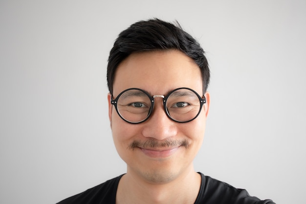 Sourire drôle de nerd asiatique avec lunettes et moustache.