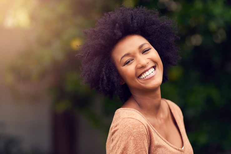 Photo le sourire du jardin et le portrait de la femme dans la nature pour l'été, l'aventure en plein air et les vacances pour se détendre, la personne féminine heureuse et le visage avec confiance dans le parc pour les voyages de vacances et la paix au soleil