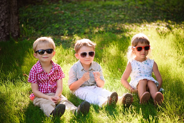 Sourire d&#39;enfants au jardin à lunettes de soleil