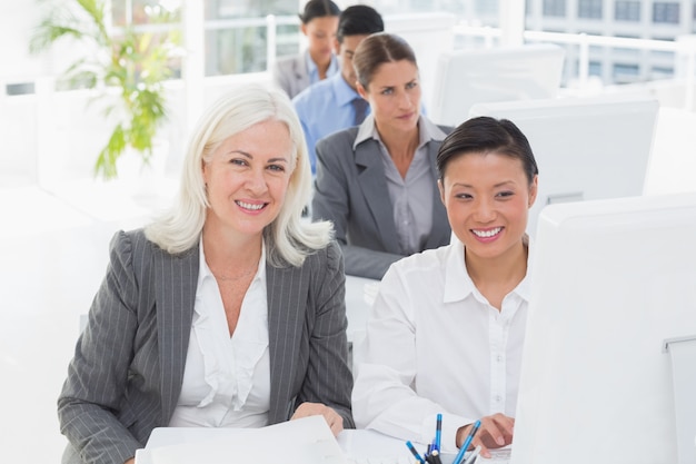 Sourire équipe de travail utilisant un ordinateur