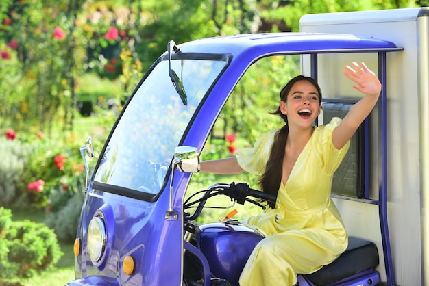 Sourire étonné jeune femme draver en voiture électrique économisant des voitures électriques écologiques