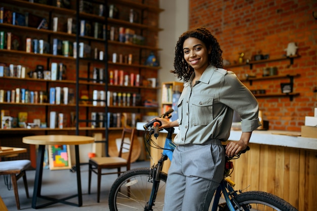 Sourire étudiante pose avec vélo au café