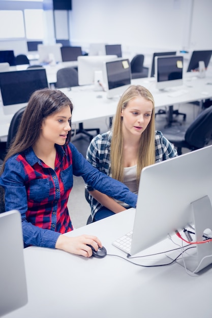 Sourire d&#39;étudiants à l&#39;aide d&#39;un ordinateur à l&#39;université